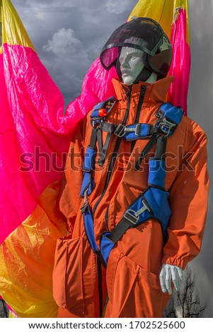 Fire paratrooper on the background of a bright parachute. Firefighter suit to extinguish forest fires. Mannequin in a fireman suit on a parachute background.