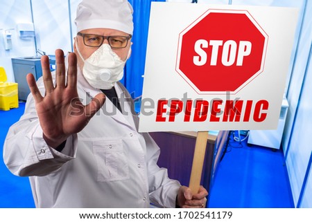 A doctor in a protective mask with a placard Stop epidemic. The doctor makes a warning gesture with his hand. The medic calls for the respect of quarantine measures. Recommendations of doctors.