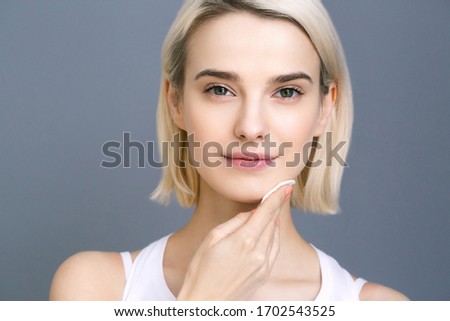 Cotton pad woman face cosmetic remove make up beauty female healthy skin model over gray background  Royalty-Free Stock Photo #1702543525