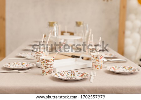 Table setting with dishes for a birthday party. Children's holiday. Accessories for parties Flat lay, side view.