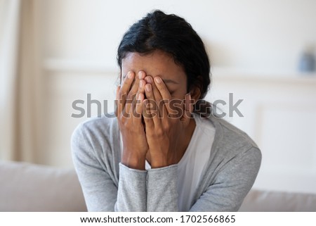 Close up of sad and crying black woman, cover face with hands, worried about problem at work, suffering from bullying or discrimination, unhappy alone girl, depression, difficult breakup or divorce Royalty-Free Stock Photo #1702566865