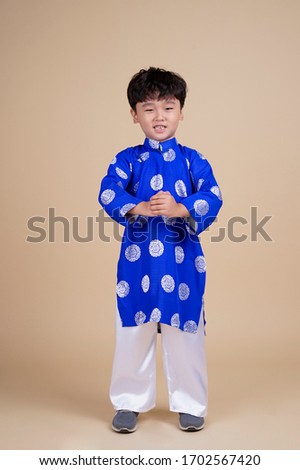 Asian handsome cute little boy kid with lovely expression in vietnamese traditional wear during Tet holiday (Vietnamese New Year)