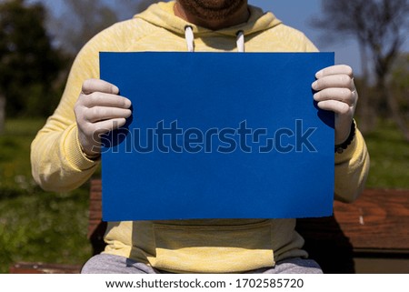 Blue chroma key paper held by a man in surgical gloves