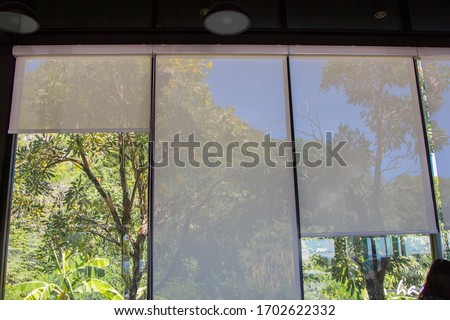 white roller blinds or curtains at the glass window Royalty-Free Stock Photo #1702622332