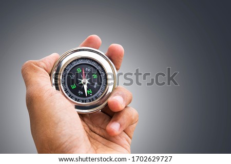 Hand holding Compass for finding direction