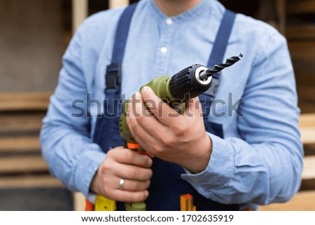 Close up picture of construction worker holding electric drill, renovation at home