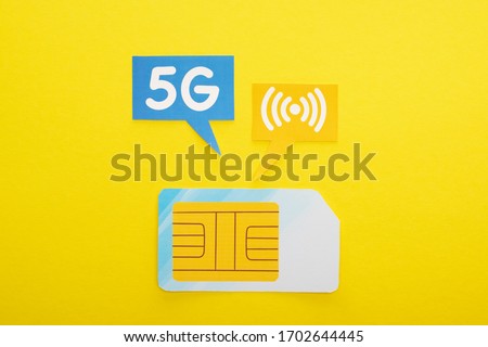top view of sim card and speech bubbles with 5g lettering on yellow background