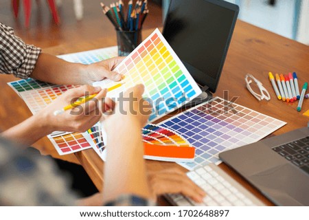 Designers discuss color samples for design work.
