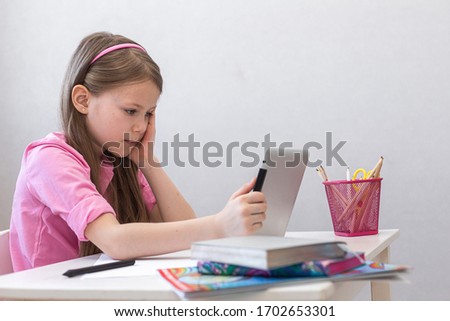School girl studying at home with tablet and doing homework. Distance learning online education. Social distance during quarantine, self-isolation, online education concept, home schooler.copy space