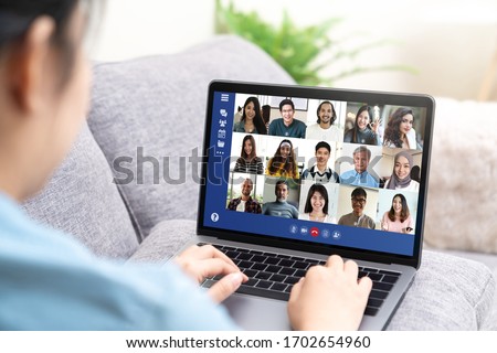 Back view of young asian business woman work remotely at home video conference remote call to corporate group. Meeting online,videocall, group discuss online concept with screen of teamwork on laptop. Royalty-Free Stock Photo #1702654960
