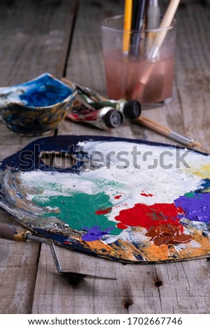 Art palette with paint and a brush