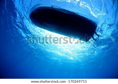 Boat silhouette under water with beautiful sun ray.