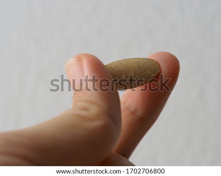 A tablet of vitamin c held between fingers