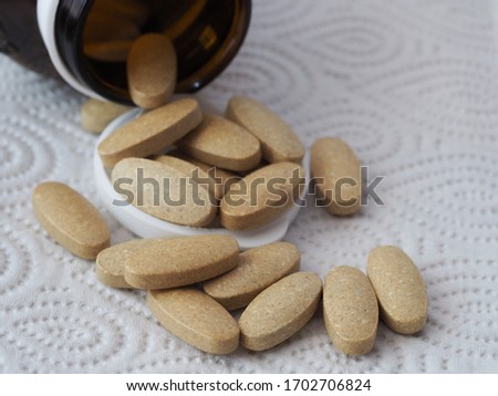 A pile of vitamin c tablets coming out from the bottle