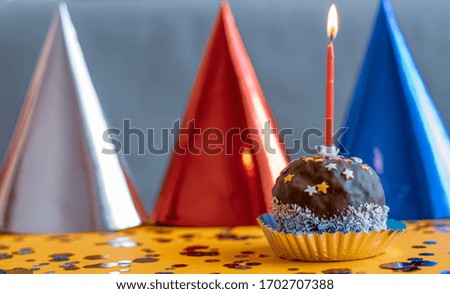 Cake with a candle and colorful caps