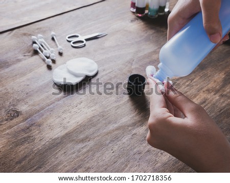 hands of a girl removing her nail varnish with acetone, cosmetics and beauty treatment Royalty-Free Stock Photo #1702718356
