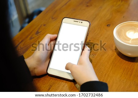 Close up of woman using cell phone sending massages  for shopping online within the cafe.having sunbath.Phone with black screen,texting,video calls.