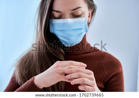 Woman in protective mask remove ring from finger. Break up relationship and divorce after living together during quarantine and isolation due to coronavirus covid epidemic. Divorce concept Royalty-Free Stock Photo #1702739665