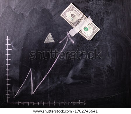 Dollar growth chart drawn on chalkboard. Investment concepts and interests Business growth. Rising graph made out of dollars.