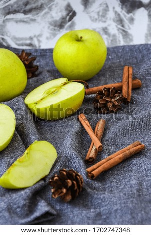 green golden apples or Granny smith with cinnamon sticks pine fir cones on kitchen towel, preparing food, dessert, healthy nutrition, autumn time