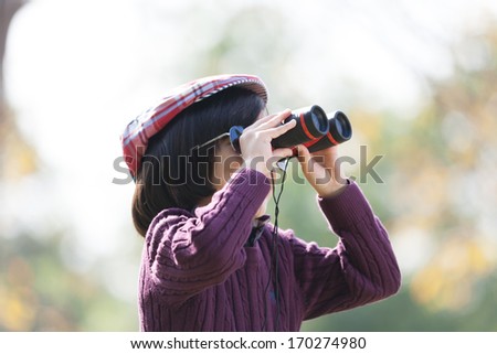 Young boy exploring by looking through binocular