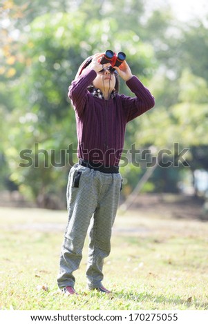 Young boy exploring by looking through binocular