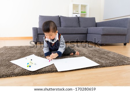 Asian baby boy drawing picture at home