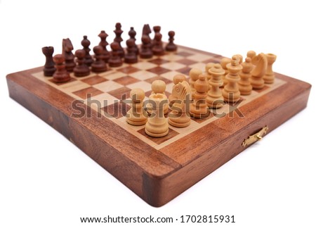 Small wooden chess board, diagonal from the front tower in focus                              