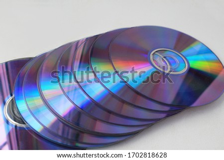Old used computer disks on a white background with a rainbow stripe.
