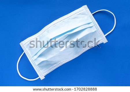 Typical 3 ply surgical face mask with rubber ear straps to cover the mouth and nose