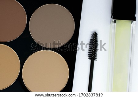 Makeup for eyebrows and eyelashes shown close up against a white background