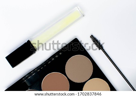 Brow makeup tools and products in a flat lay style against a white background