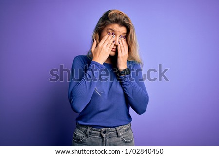 Young beautiful blonde woman wearing casual t-shirt over isolated purple background rubbing eyes for fatigue and headache, sleepy and tired expression. Vision problem