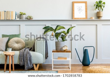 Minimalistic composition of living room with design sofa, coffe table, plant, books, decoration, pillows, plaid, carpet, wood paneling and elegant persoanl accessories in stylish home decor.