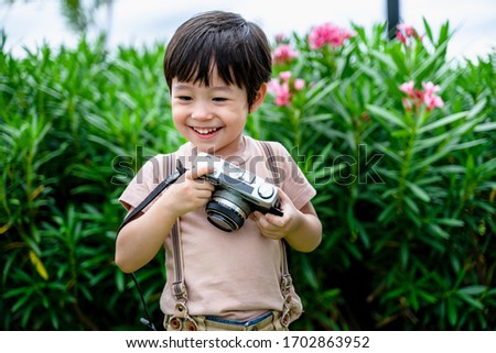 little boy fun and enjoying learning professional photographer taking a picture using a vintage retro film, Educational and learning concept.