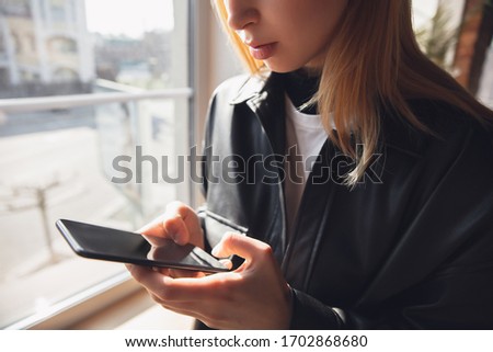 Happy and cheerful. Young woman using gadgets to watch cinema, photos, online courses, taking selfie or vlog, online shopping or surfing. Reading news, has online conference, meeting friends.