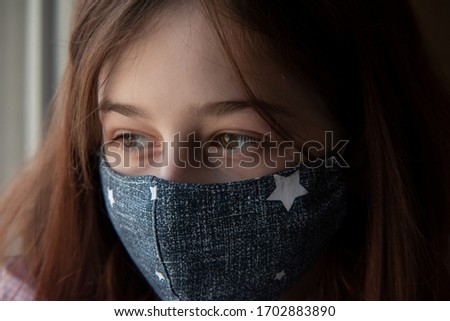 Girl in a medical protective mask. Coronavirus epidemic. Conceptual image. Symbol. Stop the virus. Protective equipment. Girl 9 years old in a medical mask. Virus. Bacteria. Teenager in red clothes