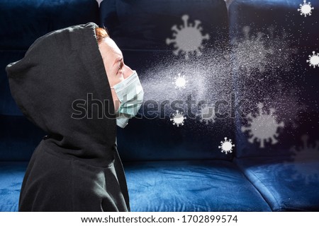 Influenza, cold, coronavirus. Infection through an airborne droplet. Girl in a hood and in a medical mask in front of a cloud of drops in the air. Visible coronavirus particles in the air Royalty-Free Stock Photo #1702899574