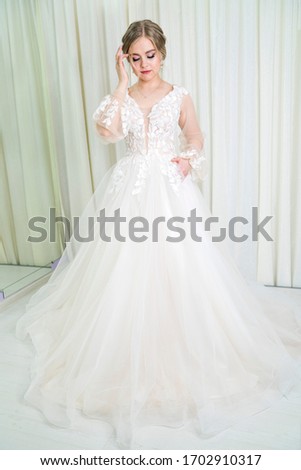 young girl of model appearance in a white wedding dress. photo session in the bridal salon