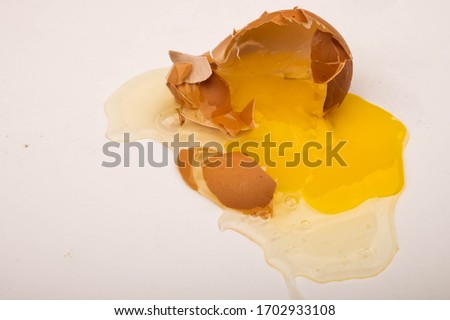 A broken chicken egg on a white background. Close up.