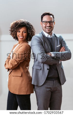 Three quarter length business portrait of cheerful multi ethnic couple