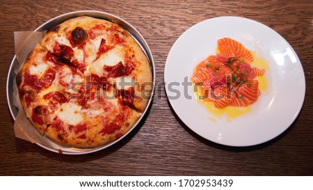 An overhead shot of a pizza next to a salmon