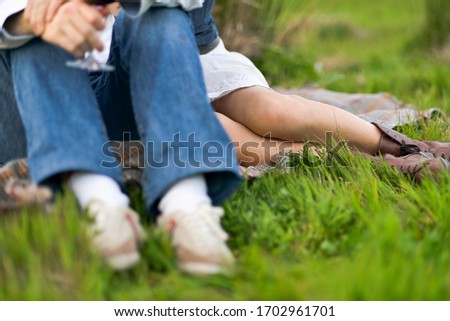 Couple sitting in meadow at sunset on picnic.
