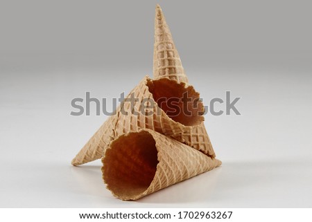 Two empty, crunchy wafer cones for ice cream isolated on white. Concept of food, treats. Mockup, template for your advertising and design. Close up