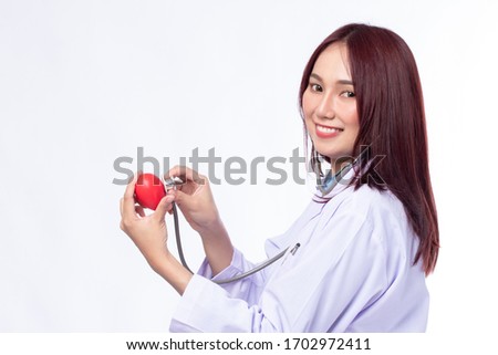 Profession healthcare people and medicine concept. Beautiful portrait friendly asian female doctor is using stethoscope to check the red heart symbol on white background.