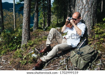Travel photographer are walking near the lake Eibsee in forest and watching the beauty of nature. Traveler concept.