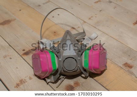 A professional respirator mask set upon a barn wood background. Royalty-Free Stock Photo #1703010295