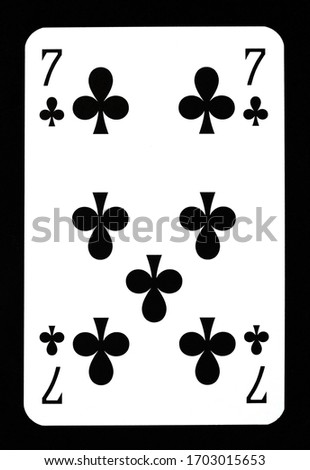 Seven of clubs playing card isolated on black.