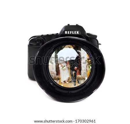 Digital photo camera on white background with groom and bride 