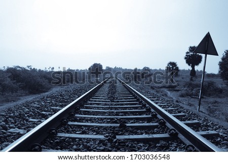a monochrome picture of rail tracks leading to horizon